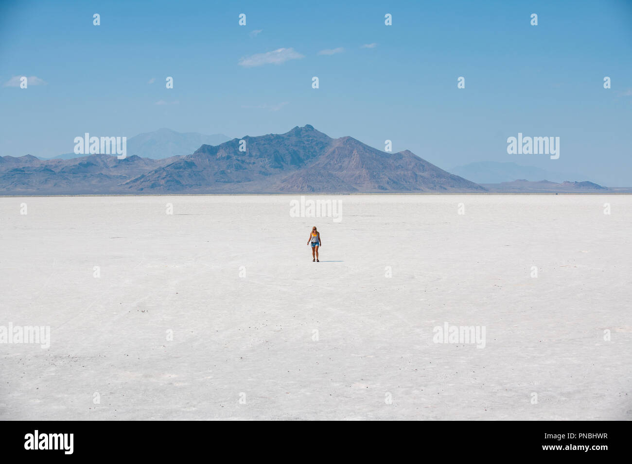 Eine blonde Frau geht über Bonneville Salt Flats, Tooele County, Utah, USA. Stockfoto