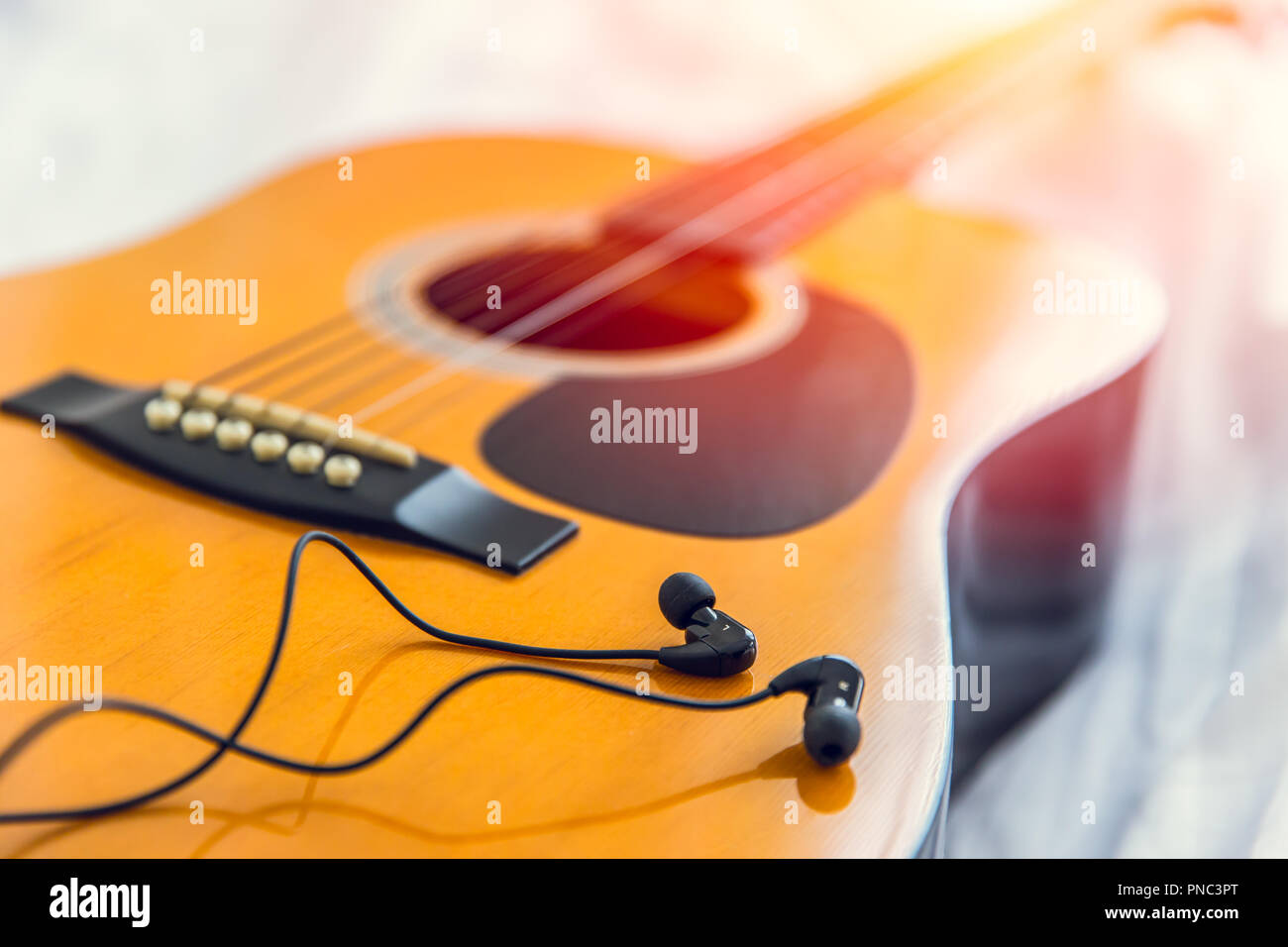Das Hören und spielen die Musik mit Gitarre, glückliche Zeit mit Song Konzept entspannen. closeup Holz folk Gitarre mit Ohrhörer Kopfhörer. Stockfoto