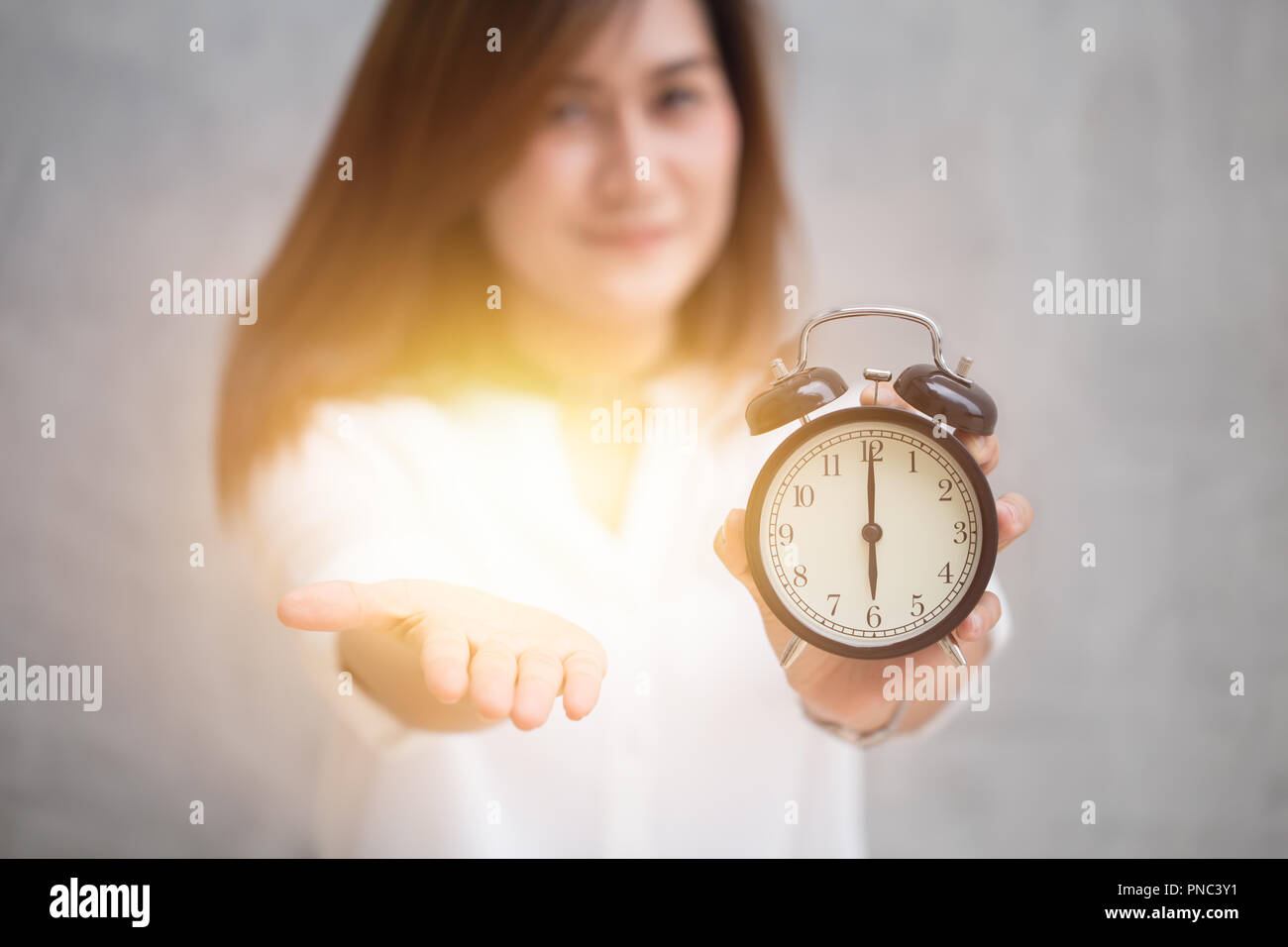 Mal das Geld bezahlen Rechnung oder Steuer jetzt, es ist Zeit, gib mir etwas Konzept, asiatische Frauen offenen Handfläche der hand und halten Sie Retro-Uhr auf 06:00. Stockfoto