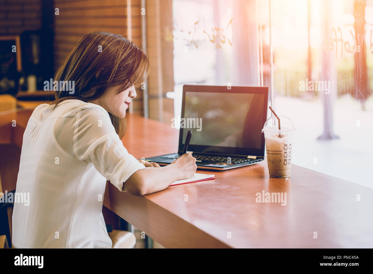 Asiatische Frauen woking im Cafe mit Laptop und schreiben Hinweis. Denken business Projekt handeln. Stockfoto