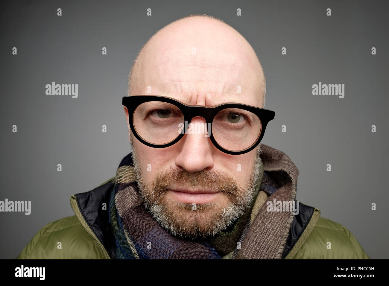 Closeup Portrait von Europäischen lustige Glatze reifer Mann denken bemüht sich an etwas erinnern, auf grauem Hintergrund verwirrt isoliert. Negative e Stockfoto