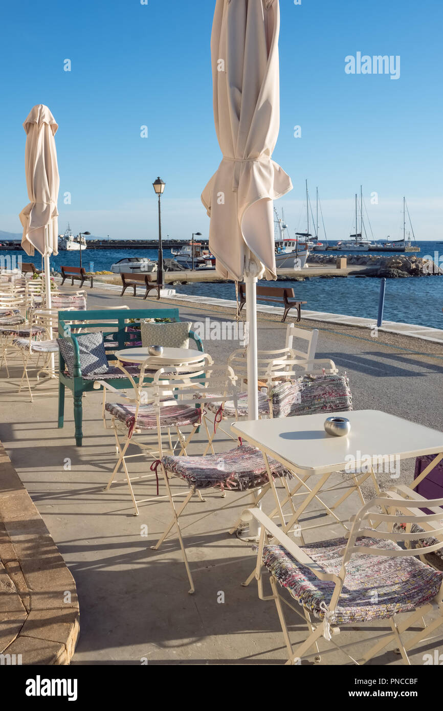 Gemütliches Café im Freien direkt am Meer im malerischen Dorf Batsi auf Andros, Kykladen, Griechenland Stockfoto