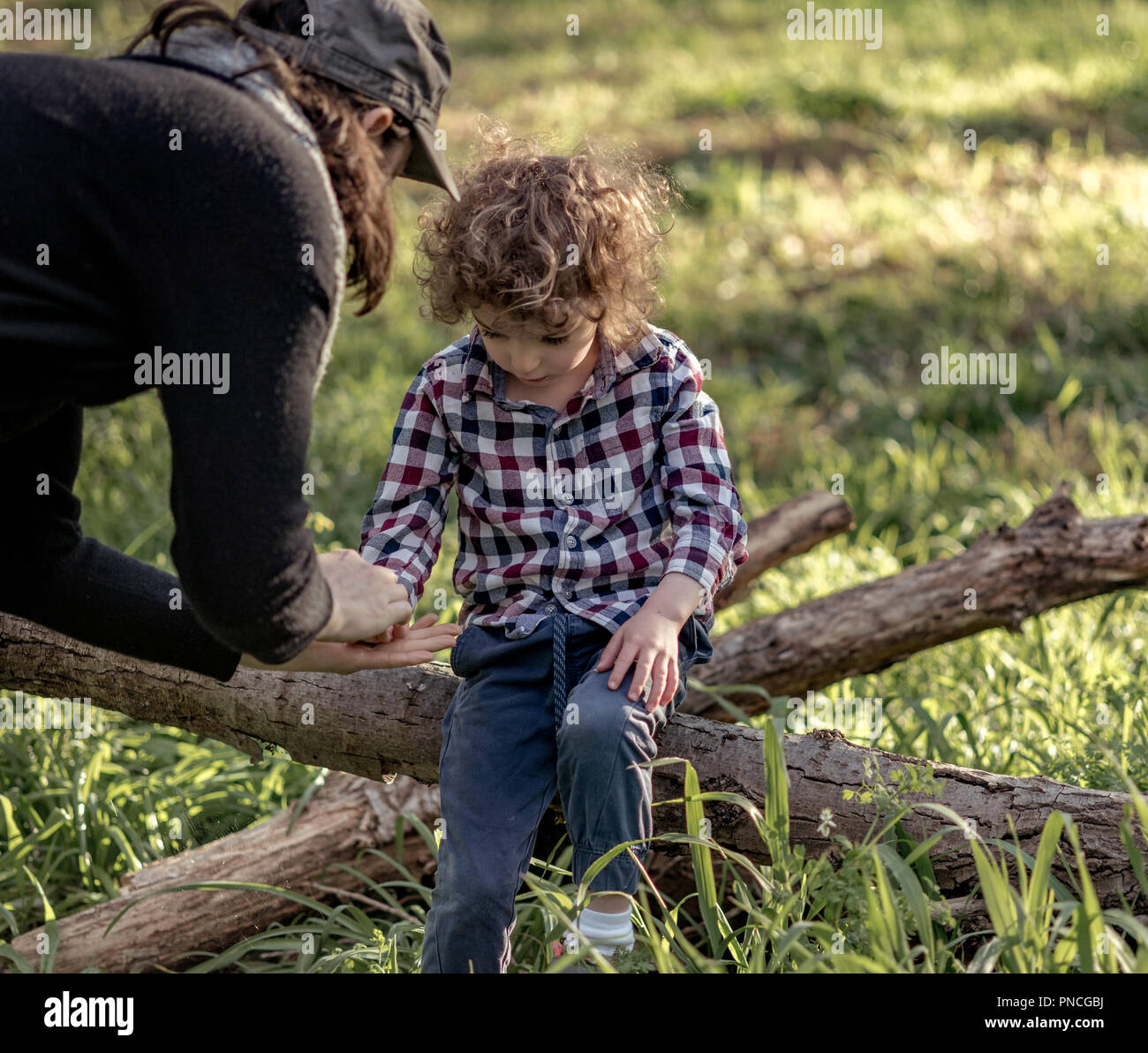Mutter hilft, kleiner Junge, nachdem er seine Hand verletzt hat, eine Frau an des kleinen Jungen kratzen Stockfoto
