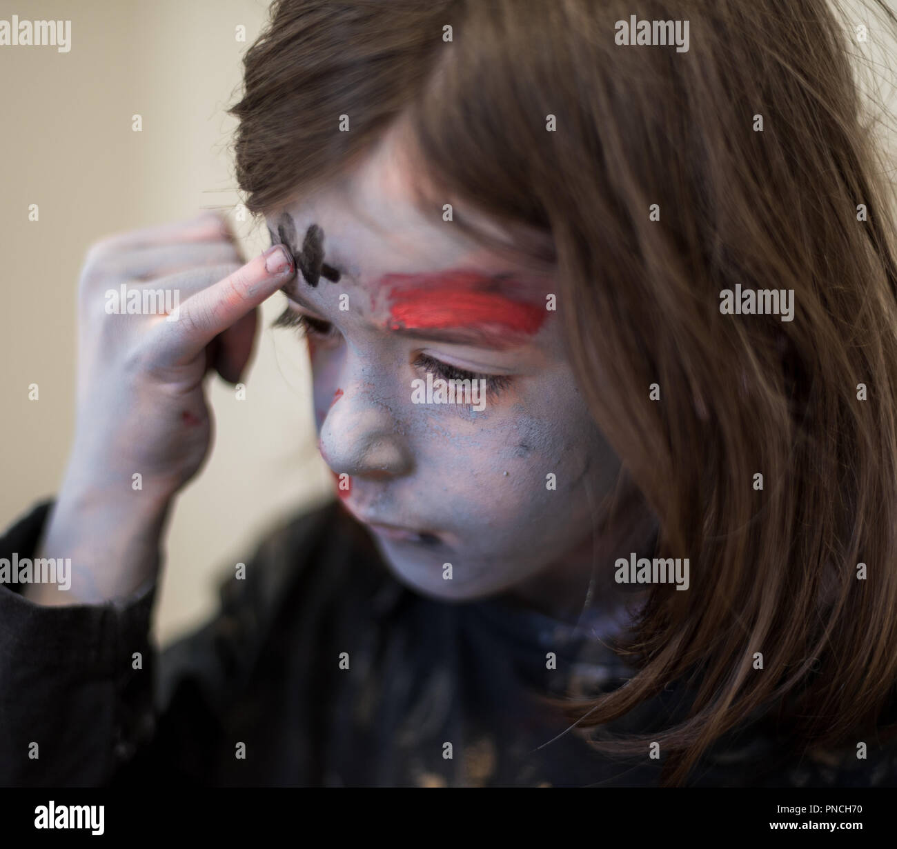 Junge Mädchen Anwendung zombie Make-up für Halloween Stockfoto