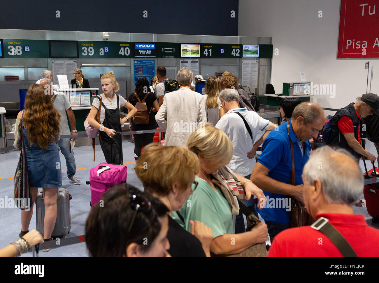 Passagiere, die Gepäck einchecken, das Terminal Innenraum, den internationalen Flughafen Pisa, Pisa, Toskana, Italien Europa Stockfoto