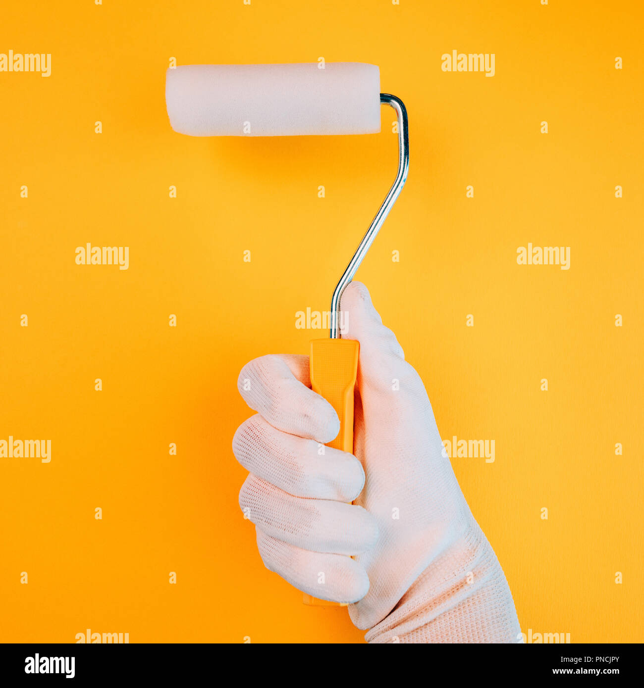 warme farben malerei, hand mit farbroller malerei eine wand in kräftigen warmen farben, Innenarchitektur