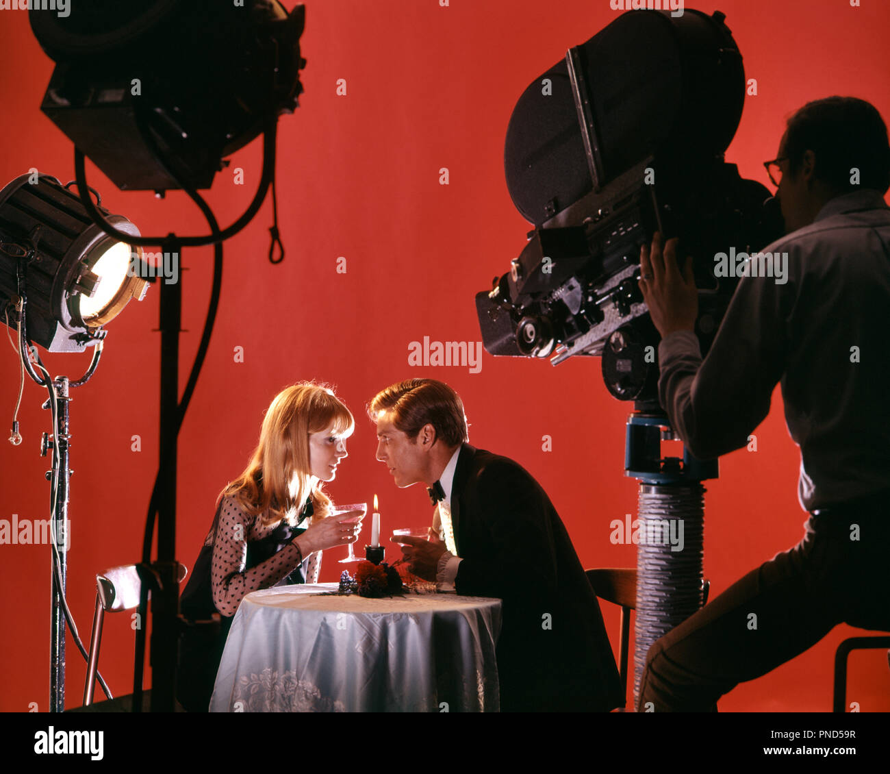 1970s 1980s Paar agieren DATUM IM RESTAURANT AUF MOVIE STUDIO FÜR TV-SPOT-kt 1327 PHT 001 HARS NOSTALGISCHE ELEKTRISCHE PAAR ROMANTIK SUBURBAN URBAN FARBE, ALTE ZEIT ZAHLEN NOSTALGIE OLD FASHION 1 GERÄT FOTOGRAF KOMMUNIKATION junger Erwachsener TEAMARBEIT KOMMERZIELLE LIFESTYLE SCHAUSPIELER FEIER FRAUEN JOBS EHEPARTNER EHEMÄNNER GROWNUP KOMMUNIKATION KOPIEREN RAUM MIT HALBER LÄNGE PERSONEN ERWACHSEN KAMERAMANN UNTERHALTUNG Silhouetten, die MANN UND FRAU MÄNNER UND FRAUEN OBJEKTIV Ehemänner und Ehefrauen BILDER PERFORMING ARTS EHEGATTEN SKILL TRÄUME BERUF FÄHIGKEITEN GEHILFEN OPERATOR GEFILMT Stockfoto