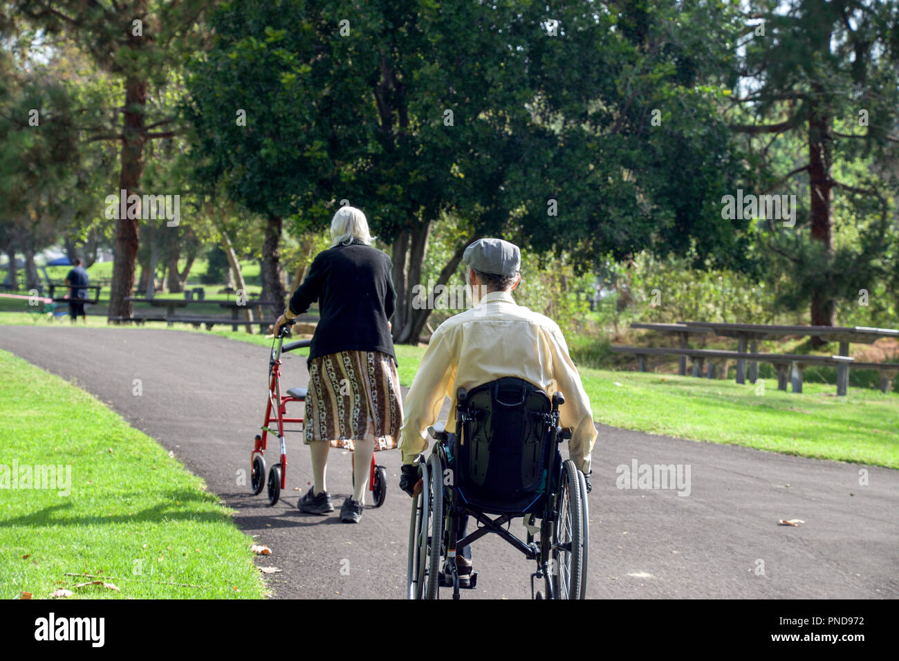 Älteres Ehepaar mit einem Rollstuhl & Walker ein Spaziergang in Yorba Regional Park in Yorba Linda, CA 2017 Stockfoto