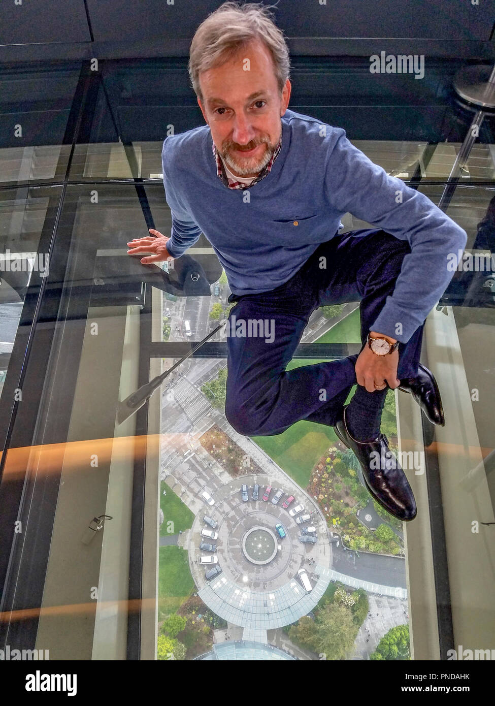 Richard Green, der 'Glas expert", dessen Firma, der Beratung, der glasboden und Aussichtsplattform für die renovierten Space Needle konzipiert. Er sitzt auf seinem glasboden mit Parkservice für die Nadel 500 Fuß unten gesehen. Stockfoto