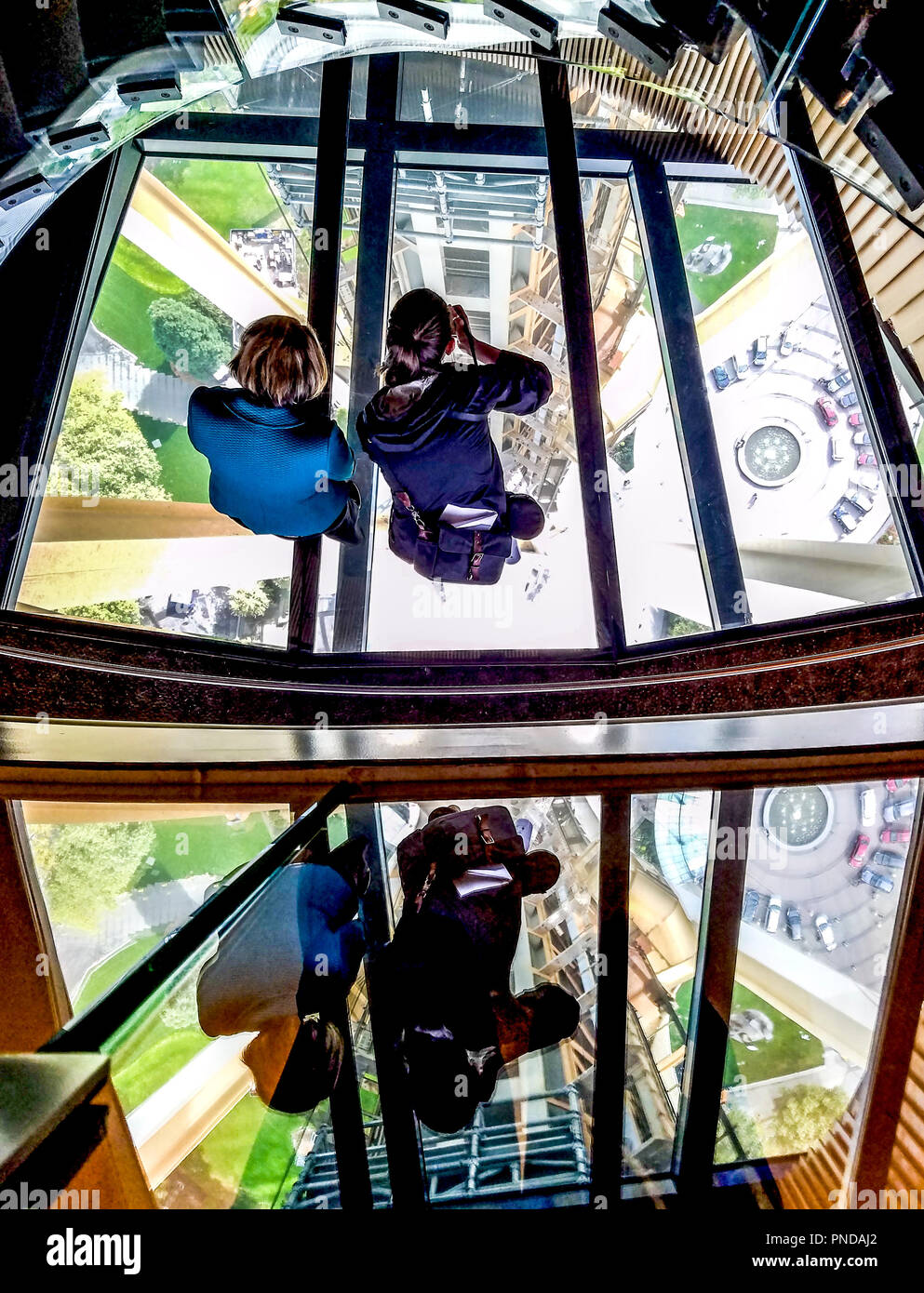 Sehen Sie die 'Oculus Treppen', die eine Verbindung zwischen der Aussichtsplattform und Glasboden des Seattle Space Needle. Sie können sehen, den Aufzug Turm, eine Ansicht nicht möglich, vor der Renovierung. Zwei Mädchen stehen auf dem Glasboden, Bilder zu machen. Sie sind in der unteren Hälfte des Bildes wider. Stockfoto