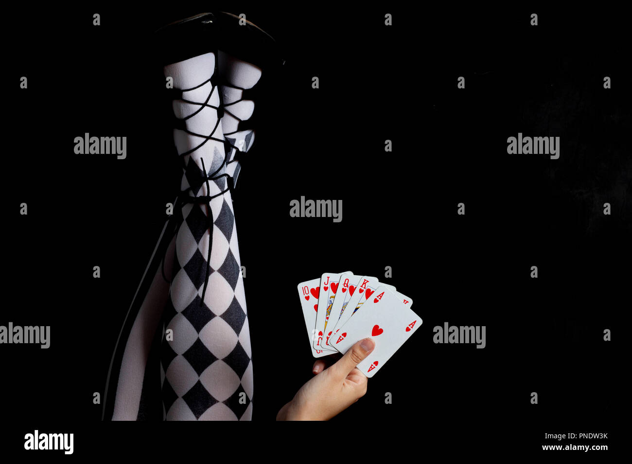 Mädchen mit Strumpfhosen halten Karten spielen - Royal Flush Stockfoto