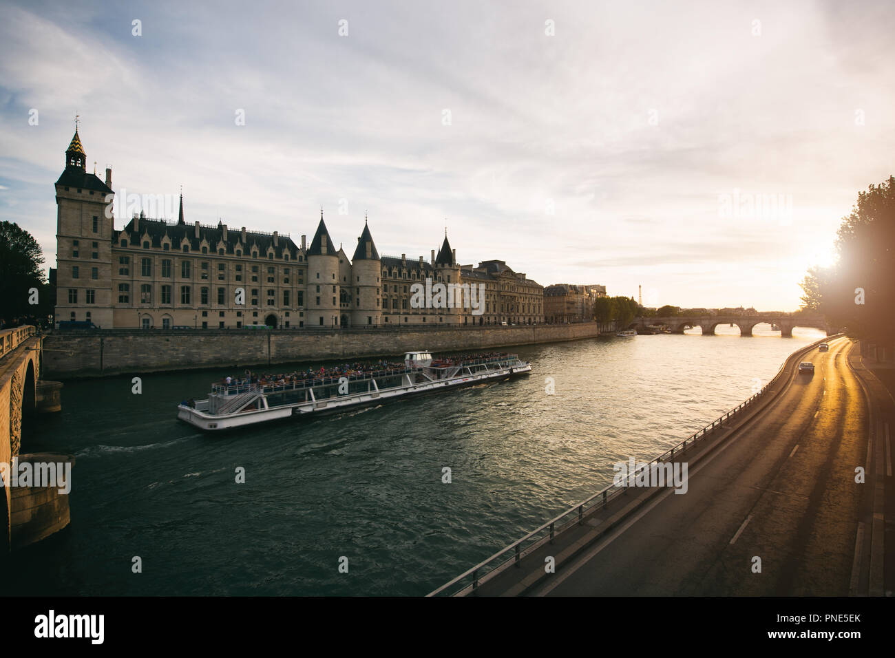 Touristische Bootsfahrt auf der Seine Fluss mit schönen Sonnenuntergang in Paris. Kreuzfahrtschiff Sehenswürdigkeiten entlang des Flusses in Paris, Frankreich. Stockfoto