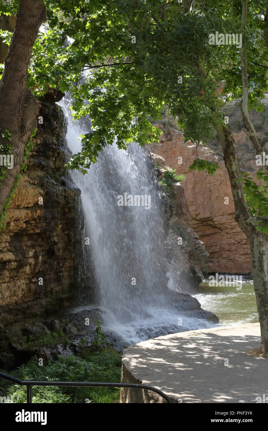 Eine Landschaft der im Viertel am Fluss Huerva River Rock doppel Wasserfälle von grünen Bäumen und Büschen in der gaël Park im Frühling umgeben, Spanien Stockfoto