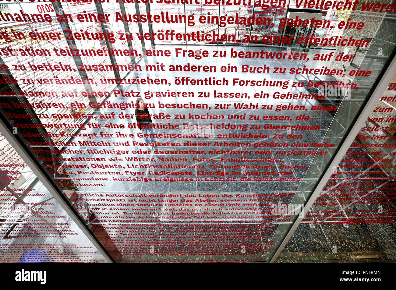 21. September 2018, Nordrhein-Westfalen, Duisburg: Die Fenster der Lehmbruck-Museum, bezeichnet der Begriff Künstler Jochen Gerz, werden durch einen Handel Besucher angezeigt. Der Künstler thematisiert acht Jahrzehnte der Zeitgeschichte von 1940 bis 2010, und die Besucher können den Blick in die Ausstellung "Der Spaziergang" von 23.09. bis 05.05.2019. Foto: Roland Weihrauch/dpa Stockfoto