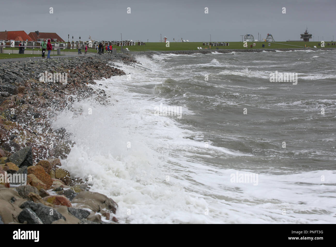 21. September 2018, Schleswig-Holstein, Büsum: Menschen gehen für einen Spaziergang am Strand von Büsum während der stürmischen Böen. Der Deutsche Wetterdienst DWD warnt vor schweren Böen von 100 km/h (Windstärke 10). Foto: Bodo Marks/dpa Stockfoto