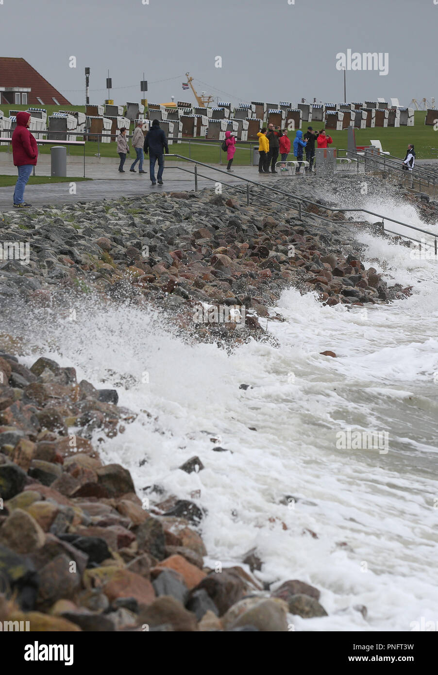 21. September 2018, Schleswig-Holstein, Büsum: Menschen gehen für einen Spaziergang am Strand von Büsum während der stürmischen Böen. Der Deutsche Wetterdienst DWD warnt vor schweren Böen von 100 km/h (Windstärke 10). Foto: Bodo Marks/dpa Stockfoto