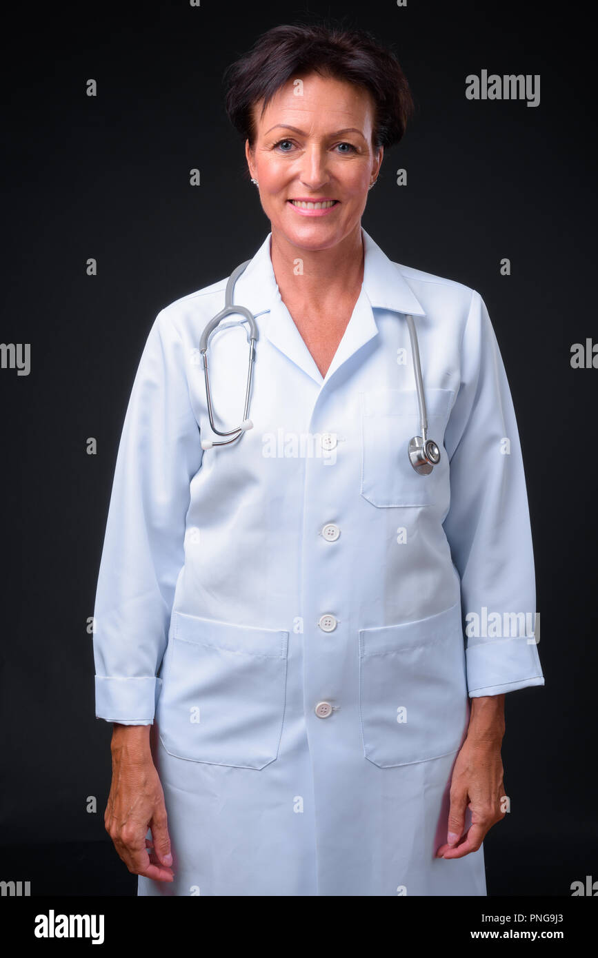 Reifen schöne Frau Doktor mit kurzen Haaren gegen Schwarz Zurück Stockfoto