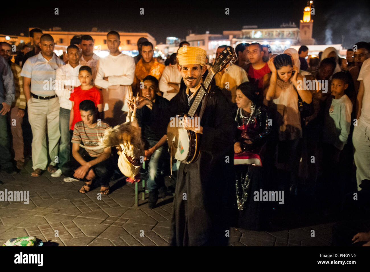 25-02-11. Marrakesch, Marokko. Ein Magier mit seinem geschulten cockerall führt in den Jemaa el-Fna in der Nacht. Foto © Simon Grosset Stockfoto