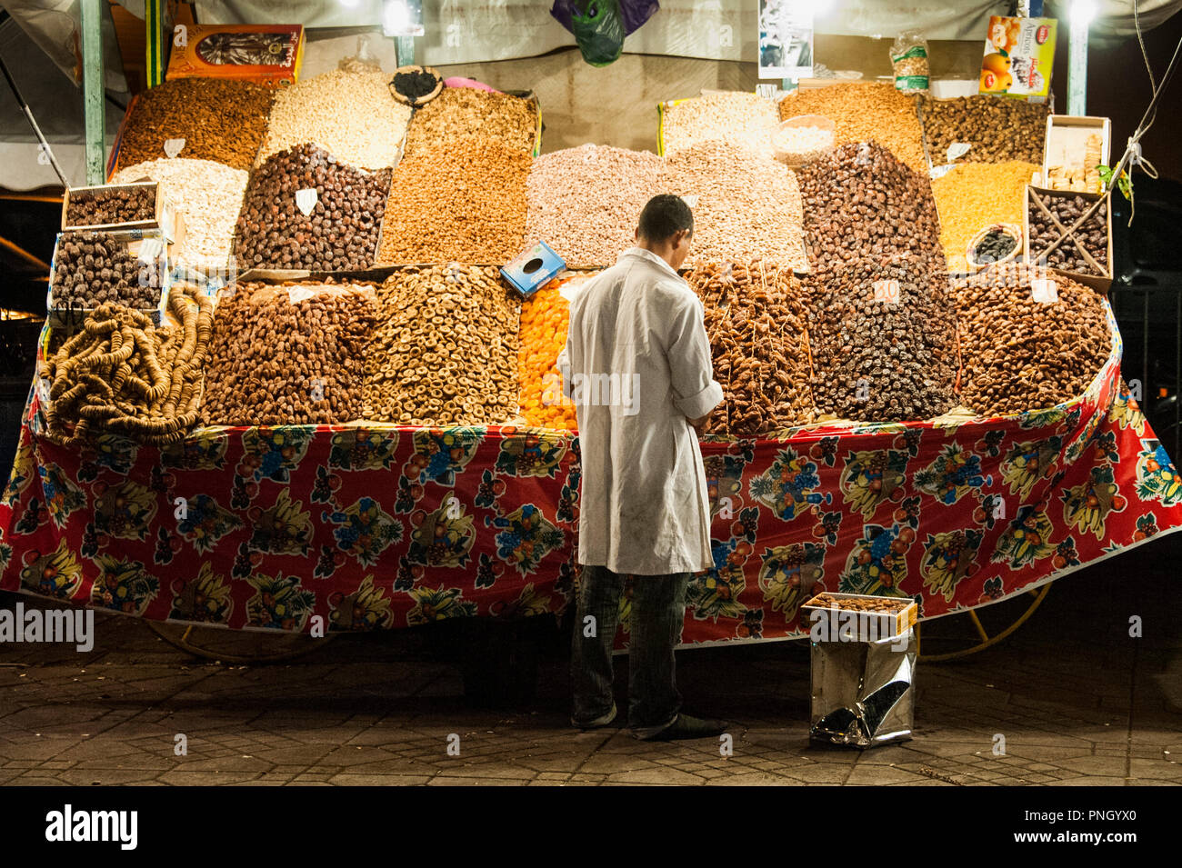 25-02-11. Marrakesch, Marokko. Inhaber verkauf Termine stall und getrocknete Aprikosen in Jemaa el-Fna in der Nacht. Es ist ein öffentlicher Platz mit kleinen merchan Stockfoto