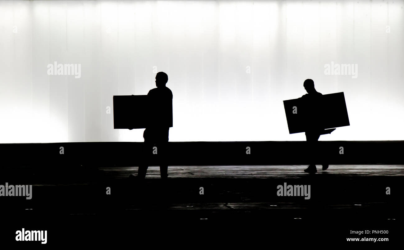Unscharfe Silhouette von zwei Personen, die jeweils ein großes Feld vor der modernen Gebäude die Nacht Stockfoto
