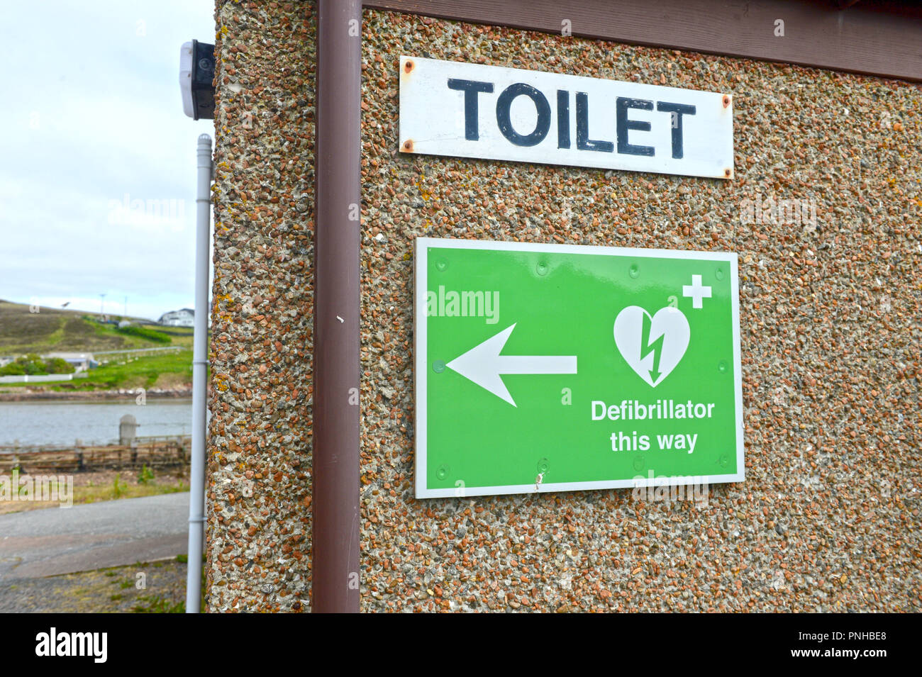 Defibrillator signage auf Wand außerhalb der öffentlichen Toiletten in Skeld Shetland Stockfoto