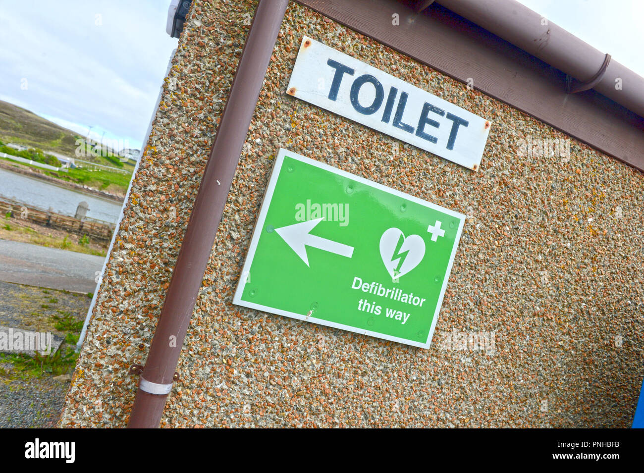 Defibrillator signage auf Wand außerhalb der öffentlichen Toiletten in Skeld Shetland Stockfoto