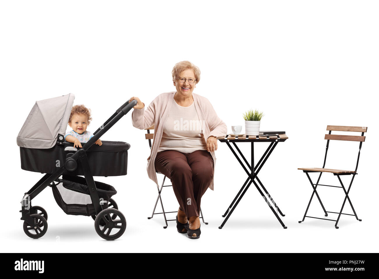 Großmutter mit einem Baby in einem Kinderwagen zu einem Couchtisch auf weißem Hintergrund sitzen Stockfoto