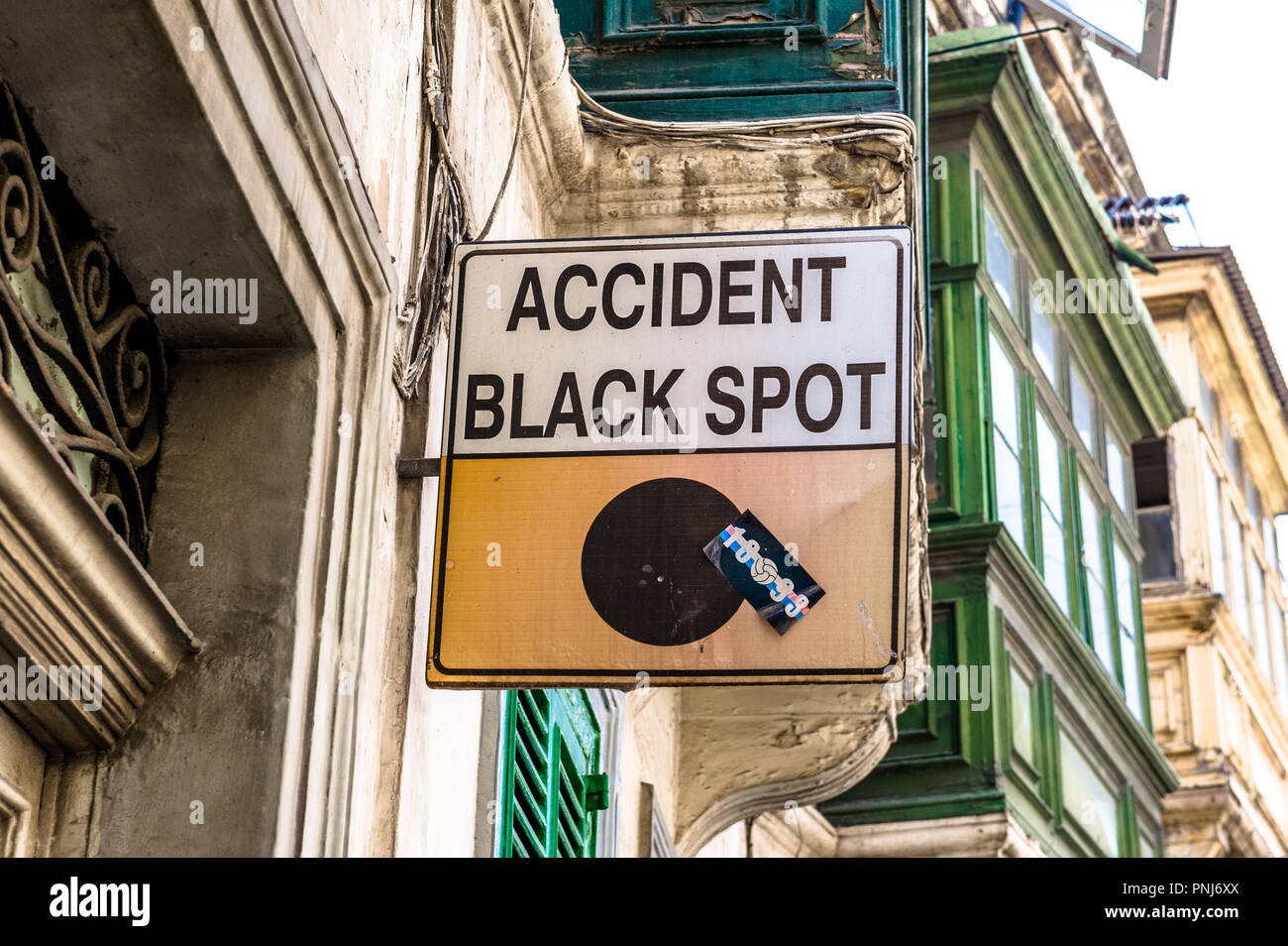 An der Wand montierte Schild "Unfall schwarzer Fleck' über eine verkehrsreiche Straße in Malta. Stockfoto