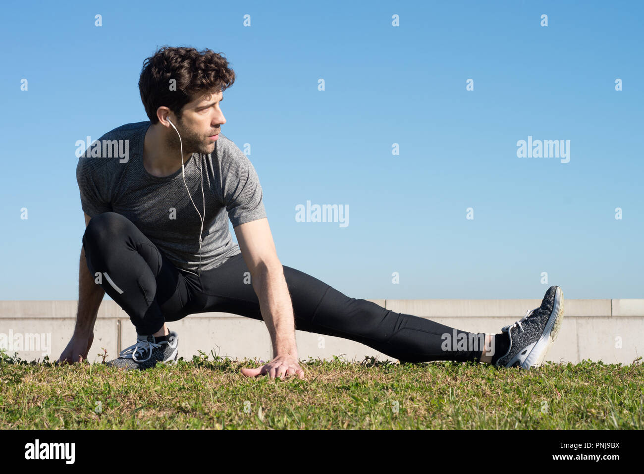 Man streckt Bein in den Boden schauen nach rechts Stockfoto