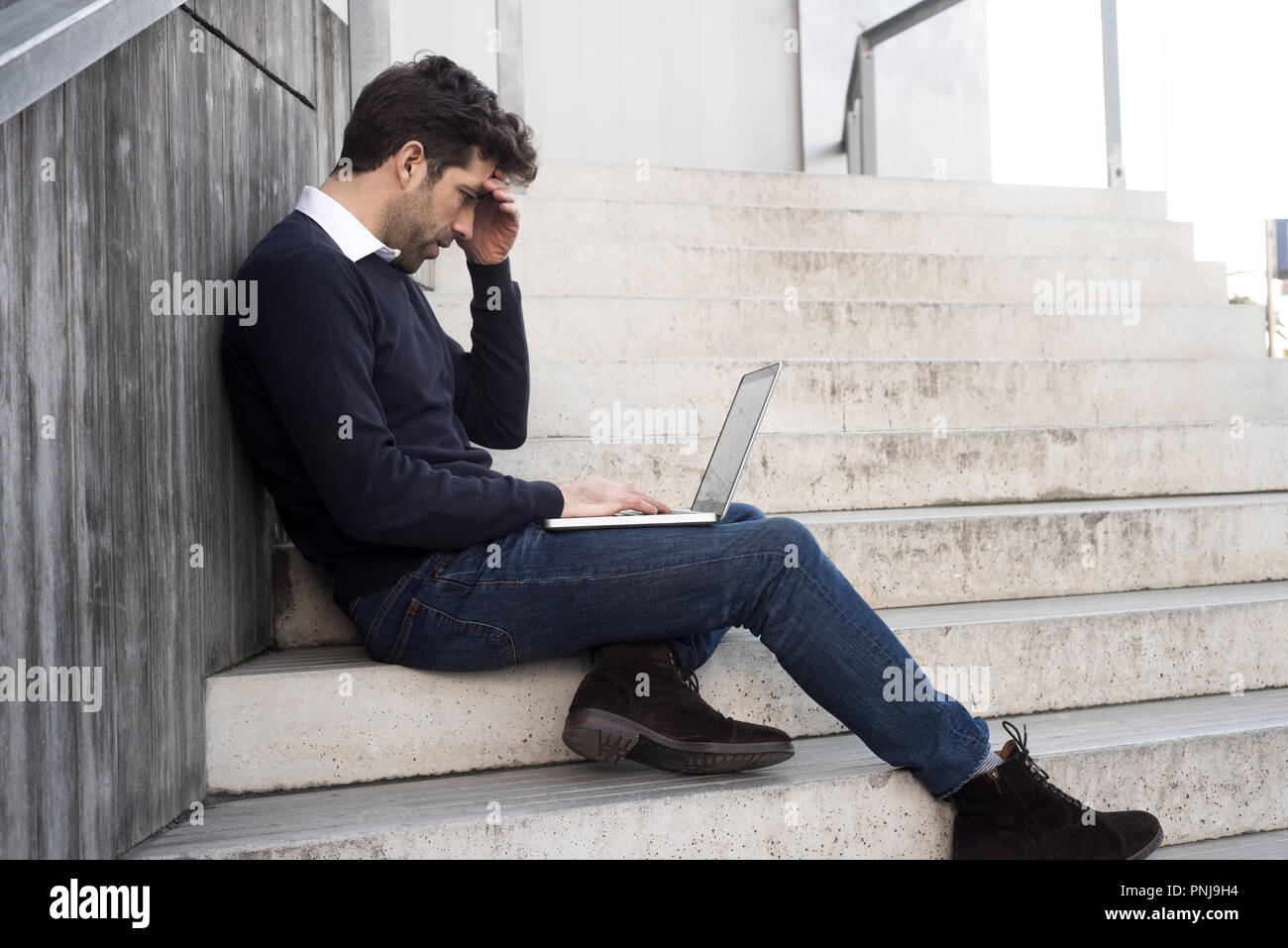 Junger Mann mit Computer und die schlechten Nachrichten Stockfoto