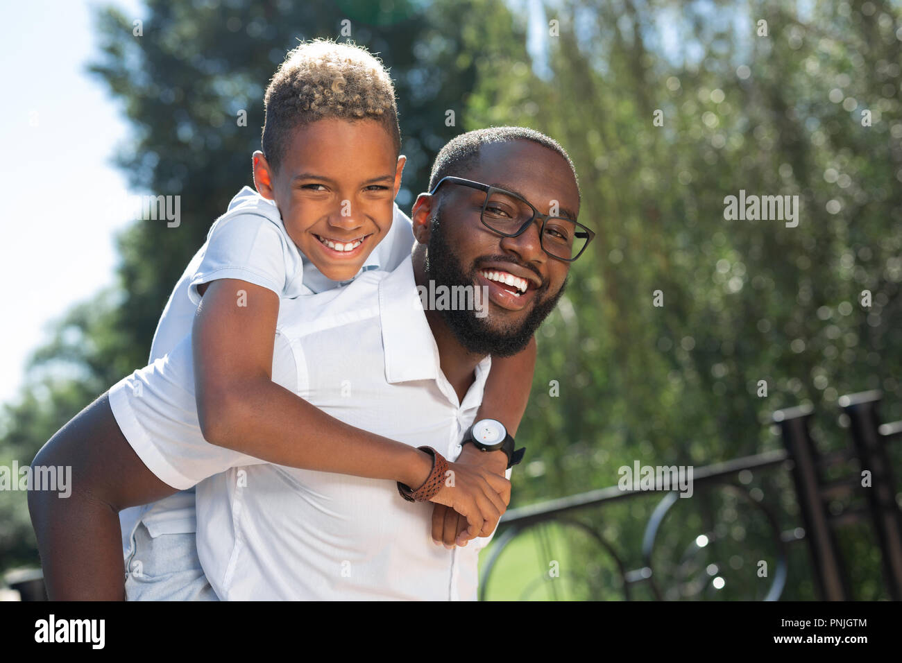 Glücklicher Mann seinen Sohn auf der Rückseite begeistert Stockfoto