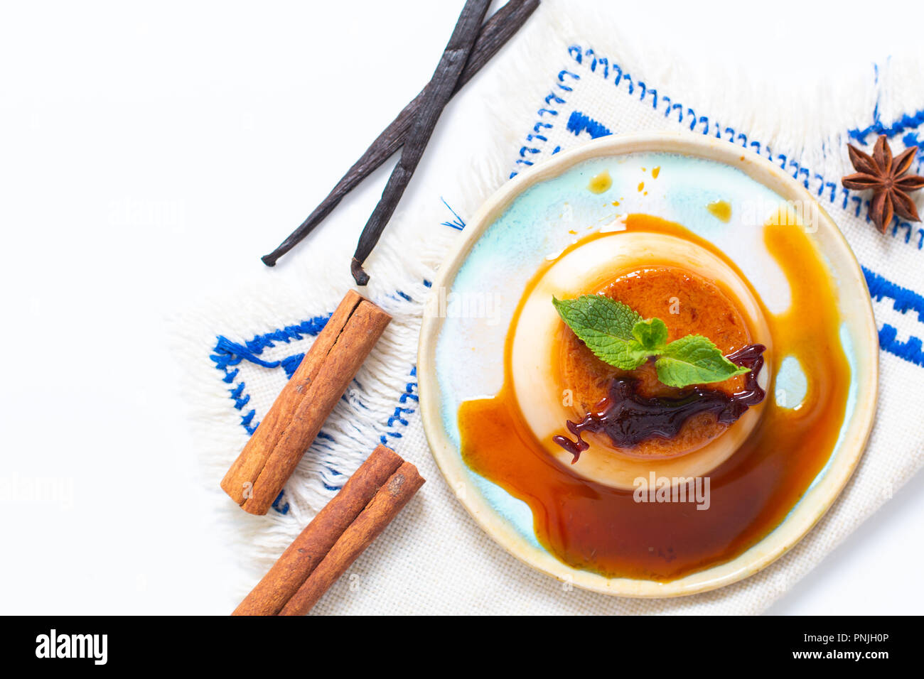 Essen Dessert Konzept hausgemachte Vanille Karamell Pudding oder Panna cotta mit Vanille und Gewürzen auf weißem Hintergrund Stockfoto