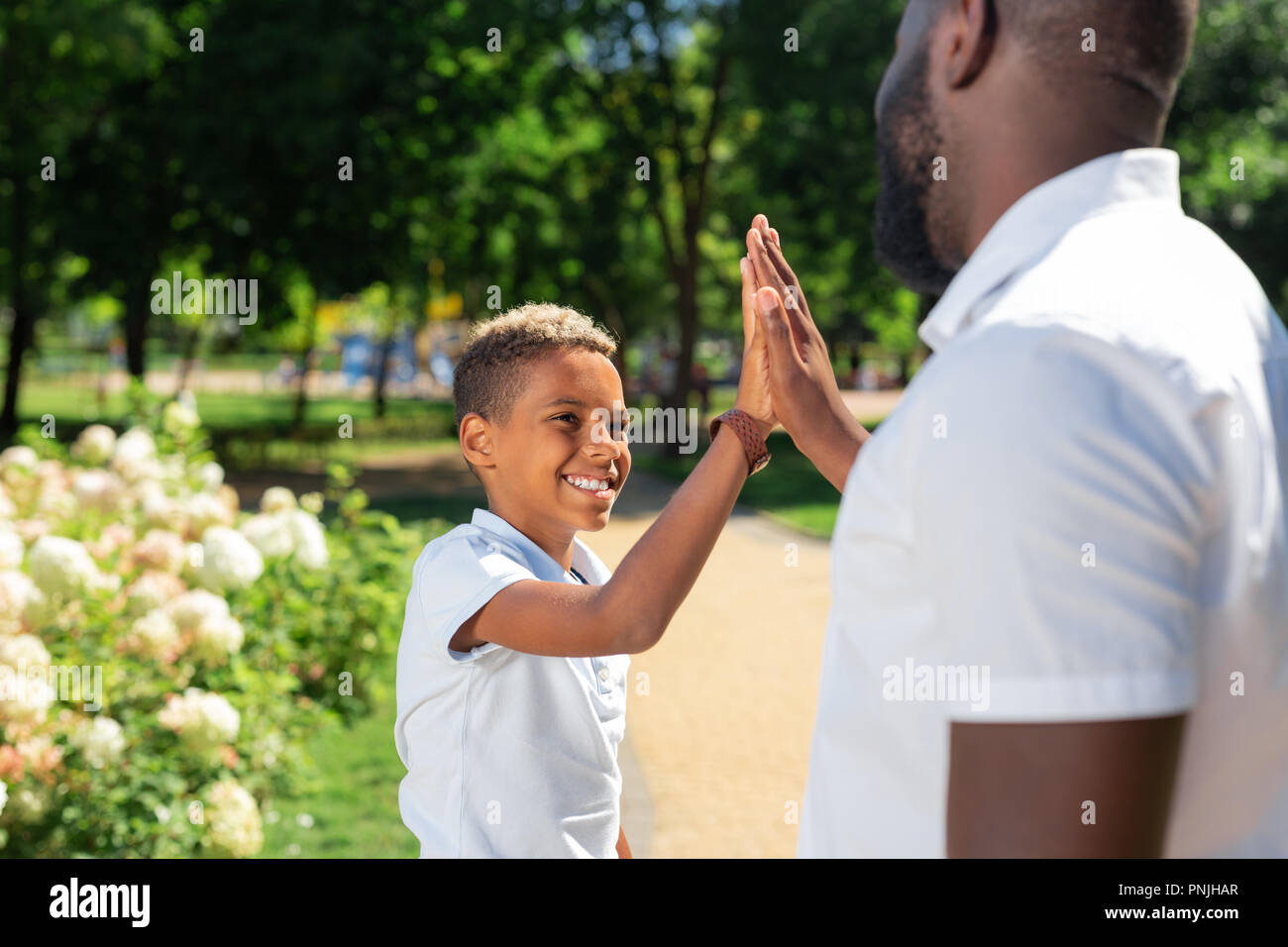 Schöne positive Junge gemeinsam mit seinem Vater Stockfoto