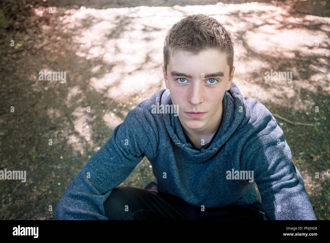 Porträt eines jungen Mannes im Dreck sitzen Stockfoto