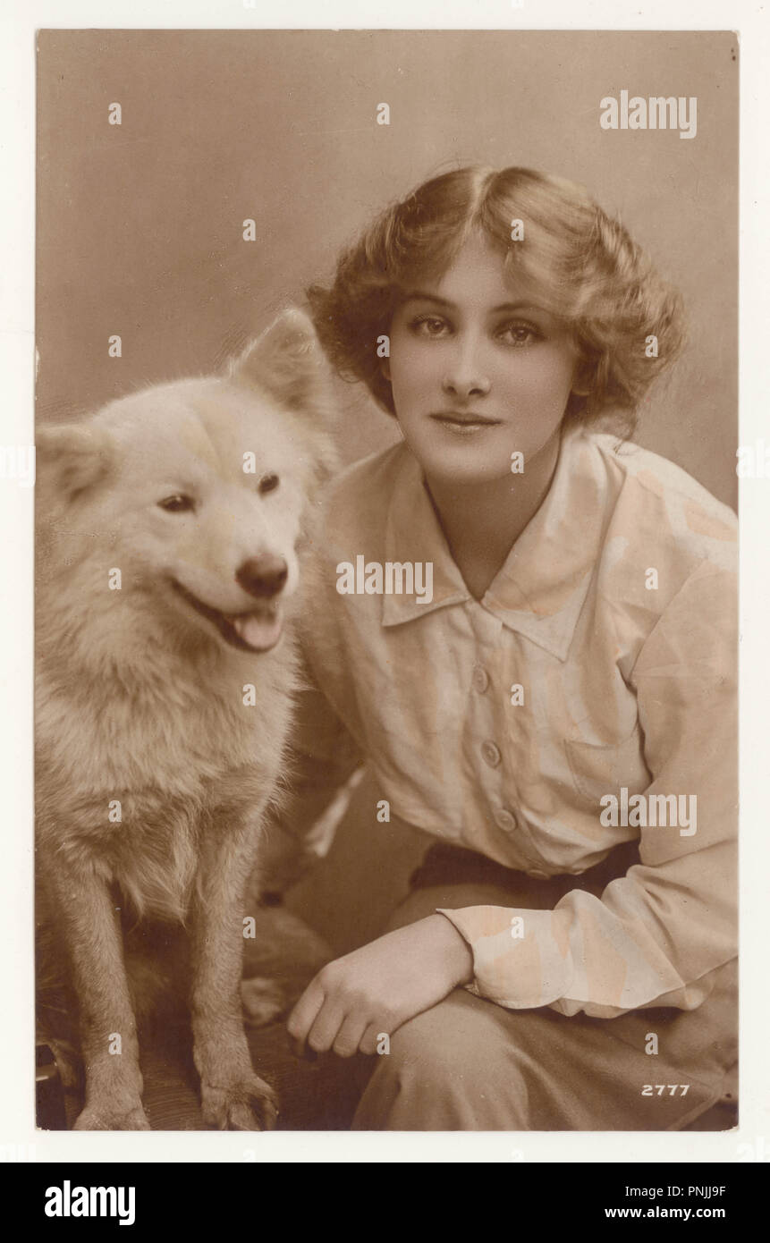 Original Anfang der 1900er Jahre getönte Sepia-Grußkarte der schönen jungen Schauspielerin Peggy Kurton mit einem Samoiden Hund, um 1916, Großbritannien Stockfoto