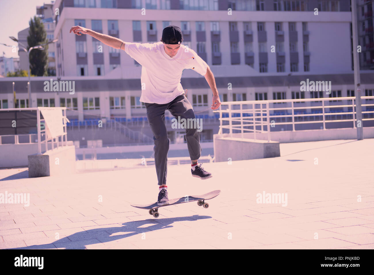 Konzentriert brunette Tun gefährliche Tricks auf dem Skateboard Stockfoto