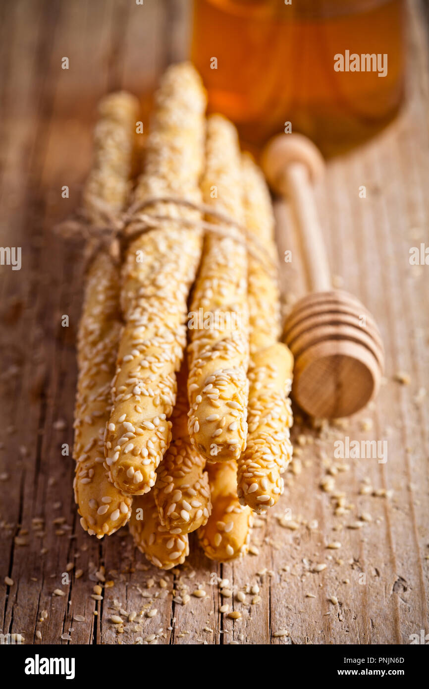 Brot sticks Grissini mit Sesam und Honig auf rustick Holzbrett Stockfoto Brot sticks Grissini mit Sesam und Honig auf rustick Holzbrett Stockfoto