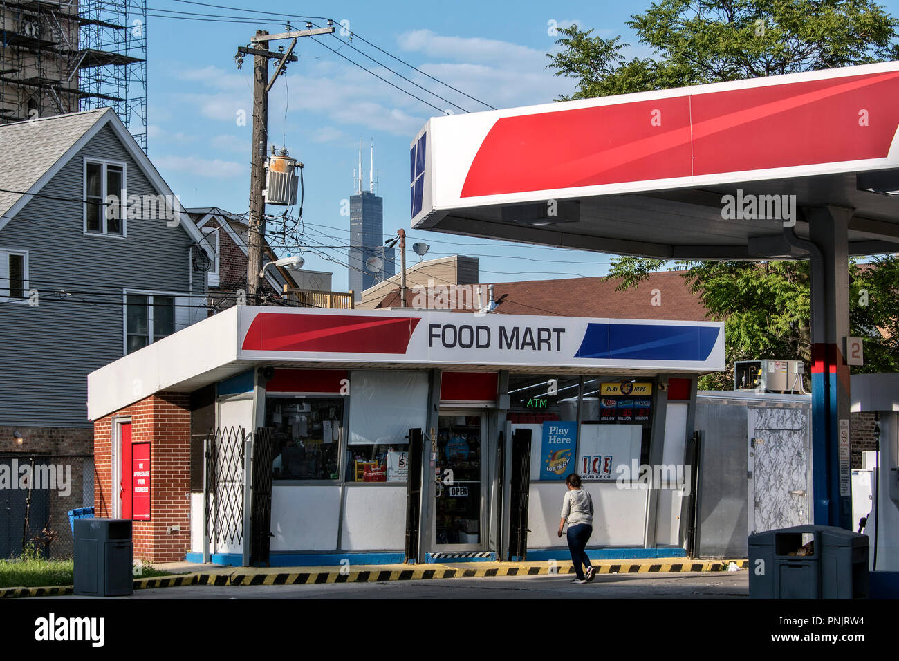 Tankstelle und Food Mart in der Pilsner Nachbarschaft, historischen Gegend auf der Lower West Side, mit Willis Tower im Hintergrund, Chicago, IL. Stockfoto