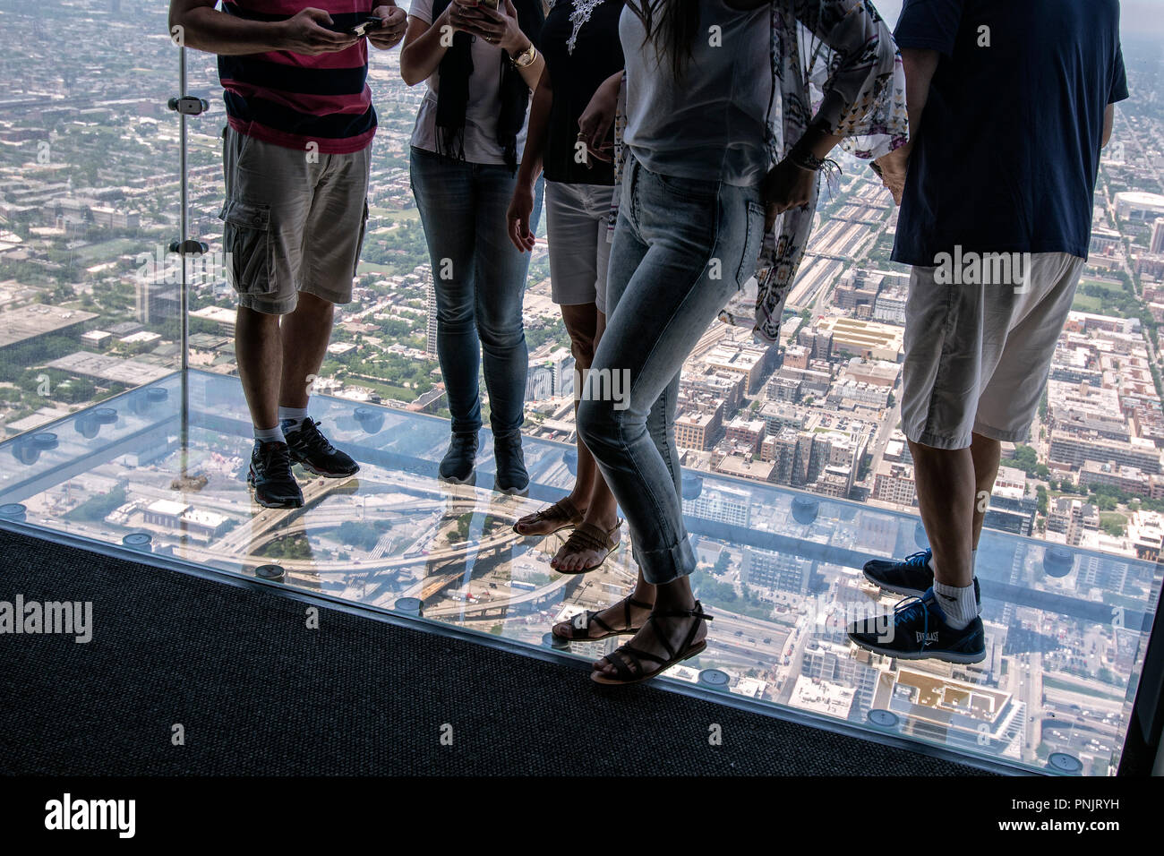 Passanten stehen mit dem glŠsernen Terras die Einfassung des Willis Tower, Chicago, IL. Stockfoto