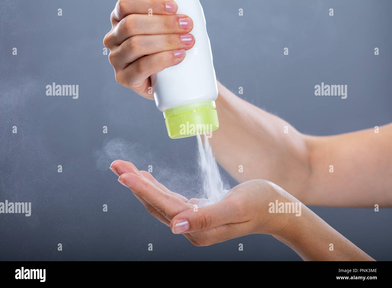 Woman's Hand mit Talkumpuder auf grauem Hintergrund Stockfoto