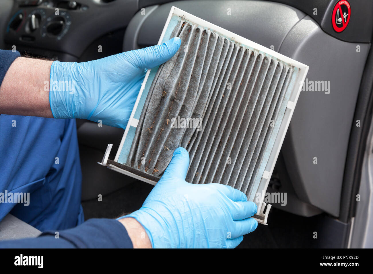 Automechaniker, durch das Tragen von schützender blaue Handschuhe,  schmutzige Auto Innenraumfilter. Altes Auto cabin Pollenfilter Austausch  Stockfotografie - Alamy