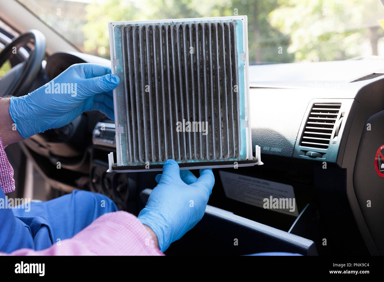 Automechaniker, durch das Tragen von schützender blaue Handschuhe,  schmutzige Auto Innenraumfilter. Altes Auto cabin Pollenfilter Austausch  Stockfotografie - Alamy