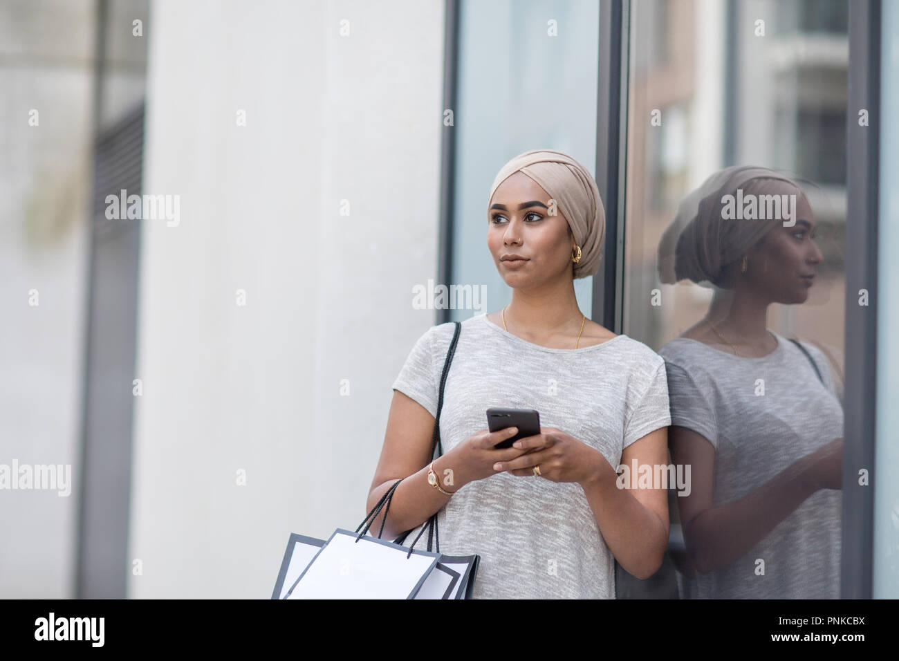 Muslimische Frau mit einem Smartphone auf Shopping-Tour Stockfoto