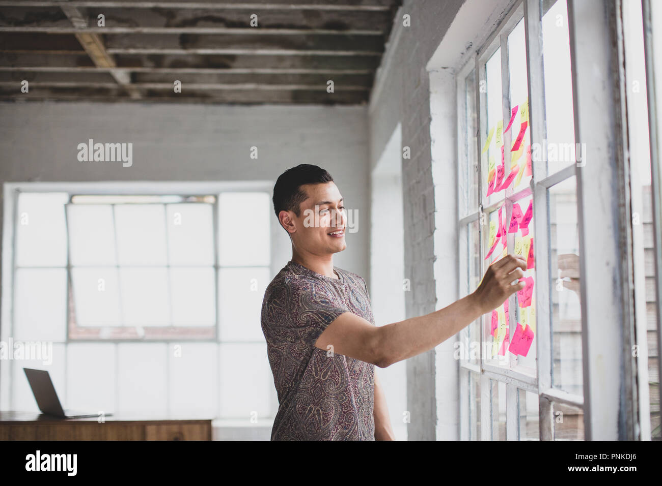 Jungen Erwachsenen männlichen Brainstorming in einer creative Office mit Haftnotizen Stockfoto