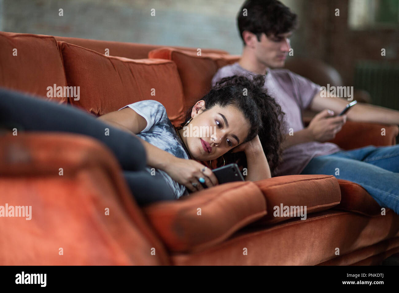 Millennials mit Smartphones entspannen auf dem Sofa Stockfoto