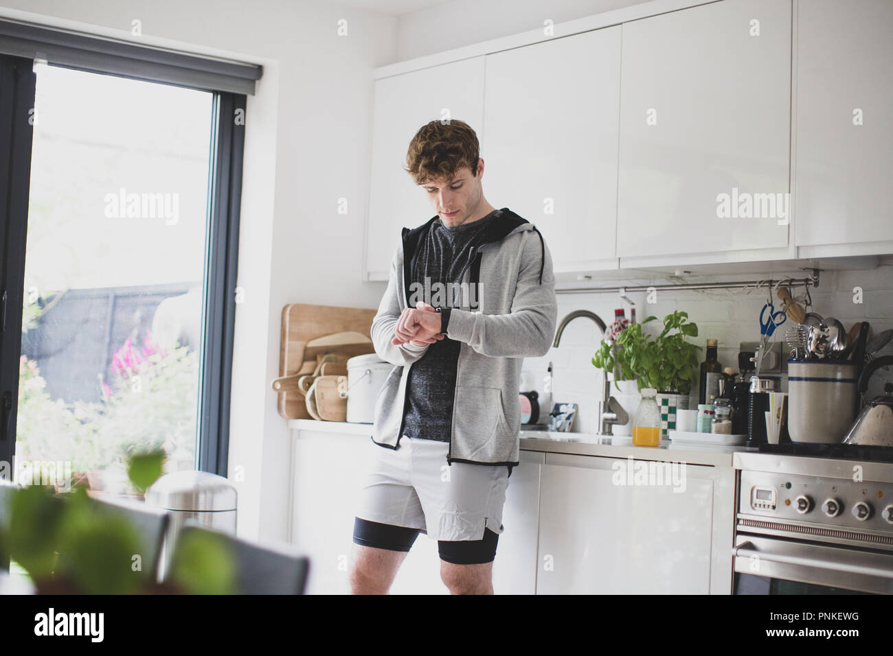 Junge Erwachsene männliche Einstellung seiner Tätigkeit Tracker vor einem Lauf Stockfoto