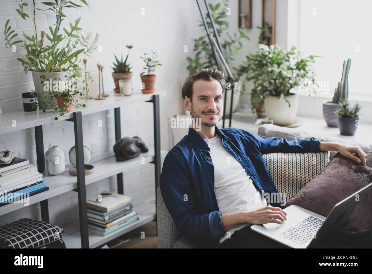 Portrait von erwachsenen männlichen arbeiten von zu Hause im Wohnzimmer Stockfoto