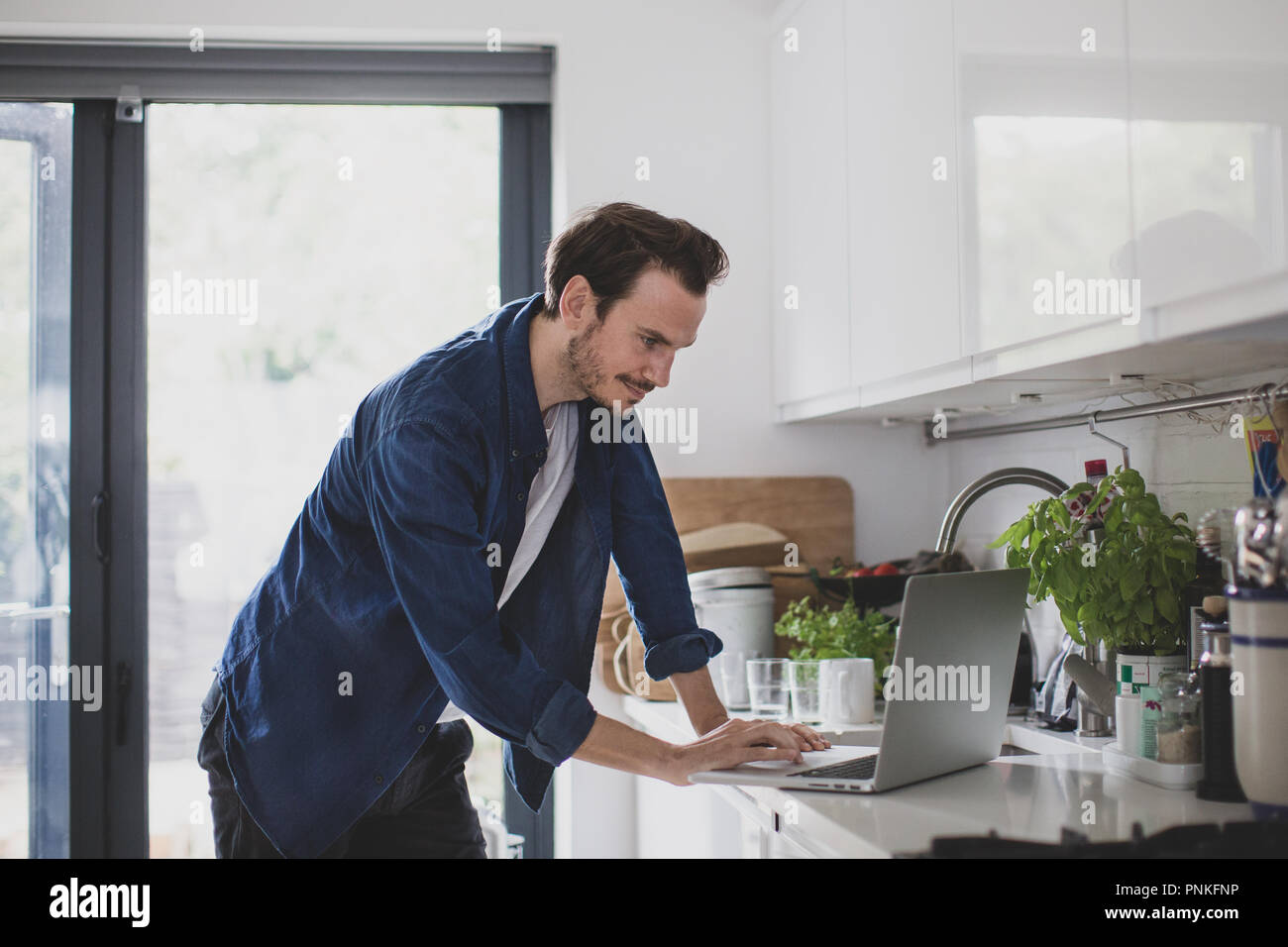 Erwachsene männliche arbeiten von zu Hause in der Küche Stockfoto