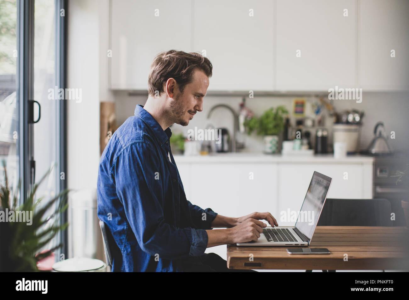 Erwachsene männliche arbeiten von zu Hause in der Küche Stockfoto