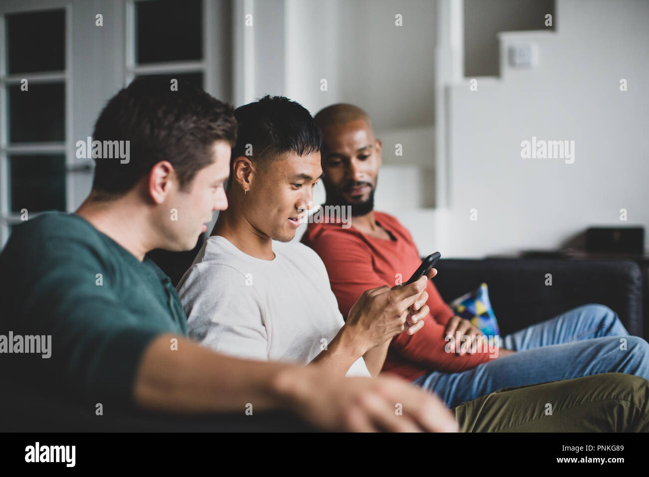 Männliche Freunde auf Smartphone zusammen Stockfoto